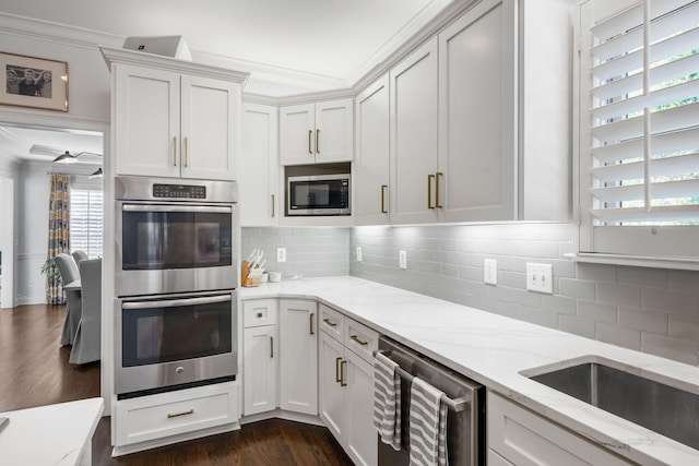 kitchen featuring wine cooler, tasteful backsplash, light stone counters, appliances with stainless steel finishes, and white cabinets