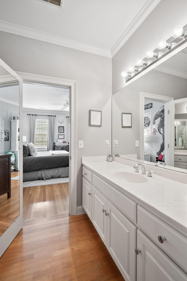 bathroom featuring crown molding, vanity, and hardwood / wood-style flooring