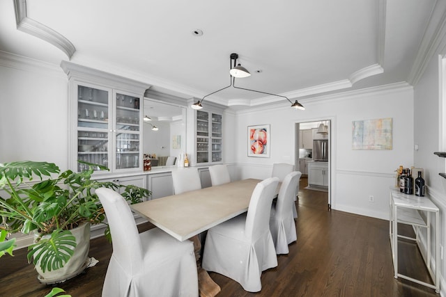 dining area featuring dark wood-type flooring and crown molding