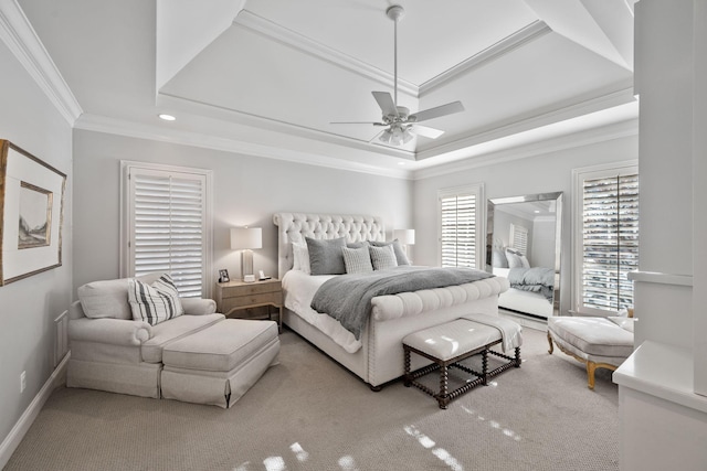 carpeted bedroom with ornamental molding, ceiling fan, and a tray ceiling