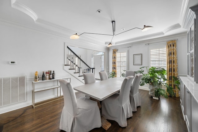 dining room featuring dark hardwood / wood-style flooring, crown molding, and a tray ceiling