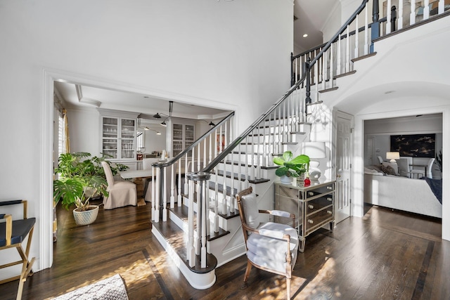 staircase featuring a high ceiling and hardwood / wood-style floors