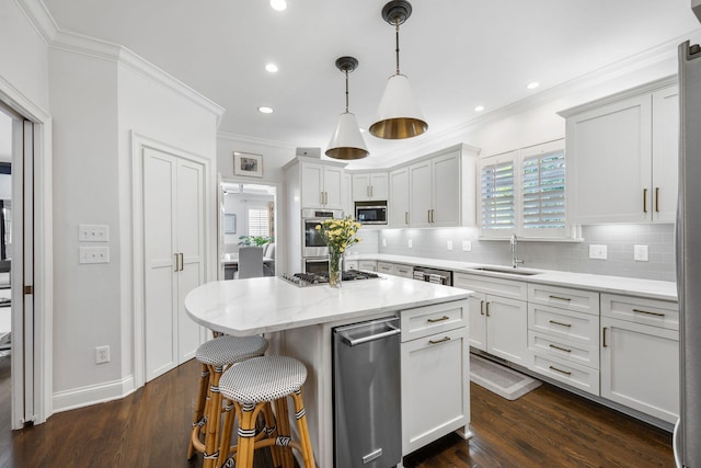 kitchen featuring sink, light stone counters, appliances with stainless steel finishes, a kitchen island, and pendant lighting