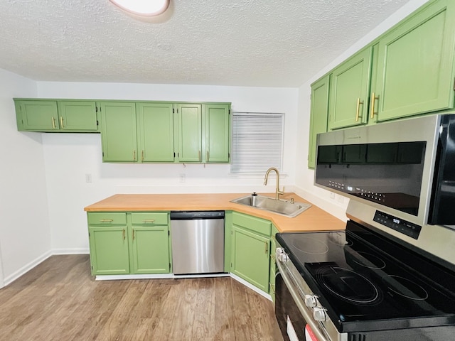 kitchen with appliances with stainless steel finishes, sink, and green cabinets