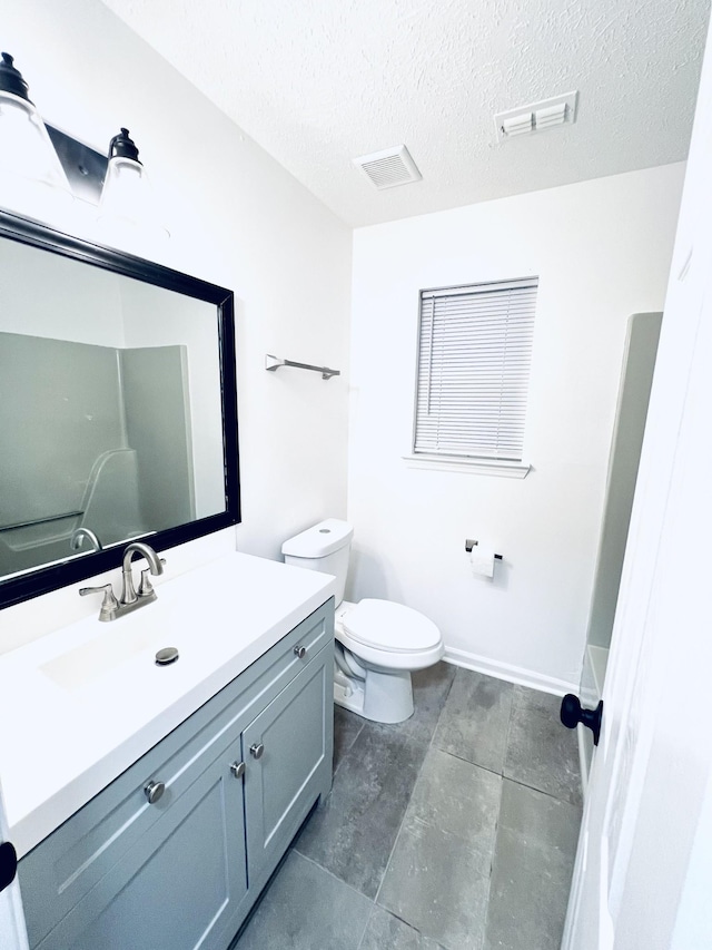 bathroom featuring vanity, a textured ceiling, and toilet