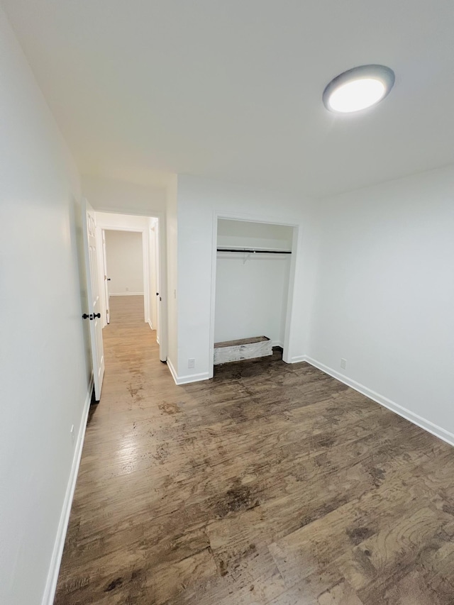 unfurnished bedroom with hardwood / wood-style flooring and a closet