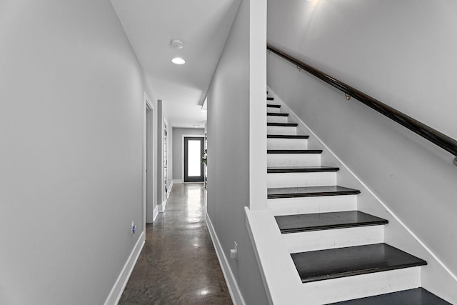 stairs with concrete flooring