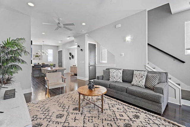 living room featuring dark hardwood / wood-style flooring and ceiling fan with notable chandelier