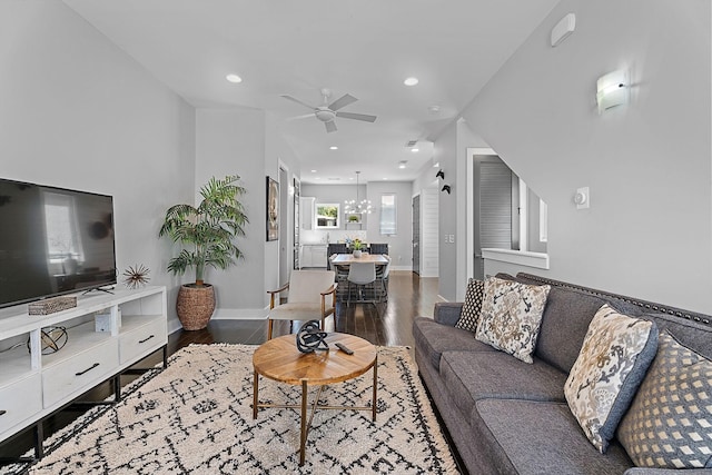 living room with hardwood / wood-style floors and ceiling fan with notable chandelier