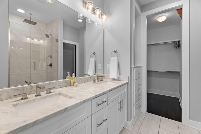 bathroom featuring a shower with door and vanity