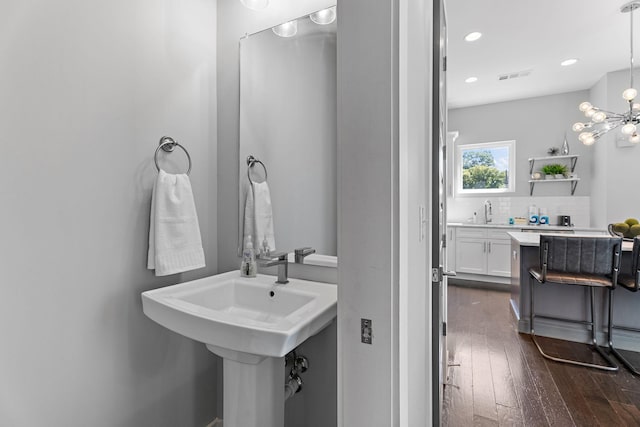 bathroom with tasteful backsplash, sink, and hardwood / wood-style floors