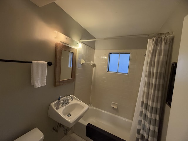 full bathroom featuring sink, shower / bath combination with curtain, and toilet