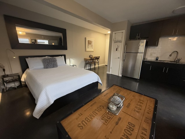 bedroom with stainless steel refrigerator and sink