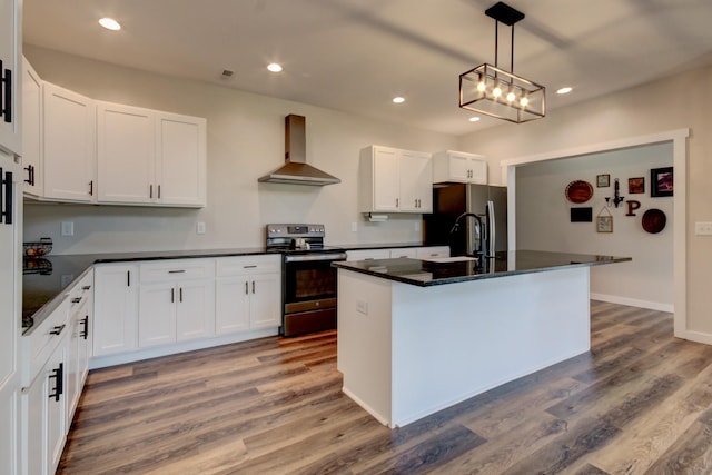 kitchen with wall chimney exhaust hood, white cabinetry, and appliances with stainless steel finishes