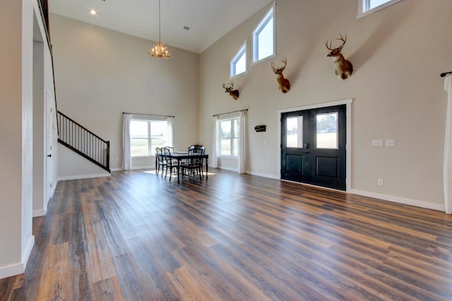 foyer entrance featuring dark hardwood / wood-style flooring, a chandelier, and a high ceiling