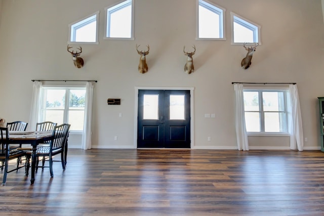 entryway with french doors, plenty of natural light, dark wood-type flooring, and high vaulted ceiling