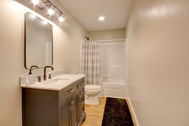 full bathroom featuring vanity, toilet, hardwood / wood-style floors, and shower / bath combo with shower curtain