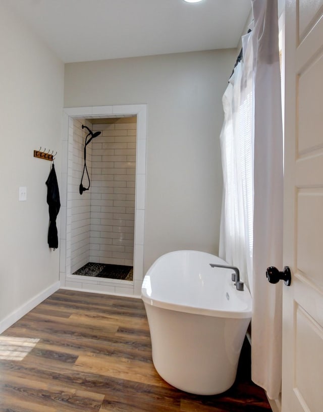 bathroom with plenty of natural light, wood-type flooring, and separate shower and tub