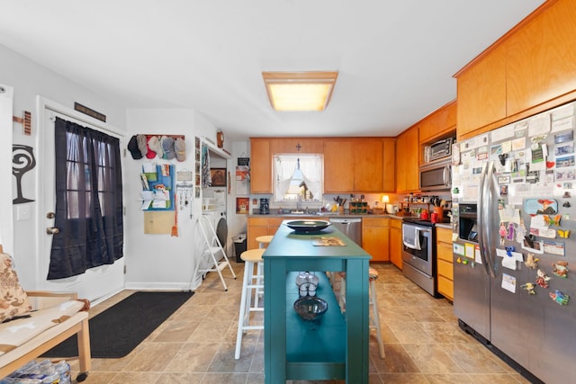 kitchen with separate washer and dryer, a breakfast bar area, stainless steel appliances, and a center island