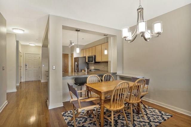 dining room featuring a notable chandelier and dark hardwood / wood-style floors