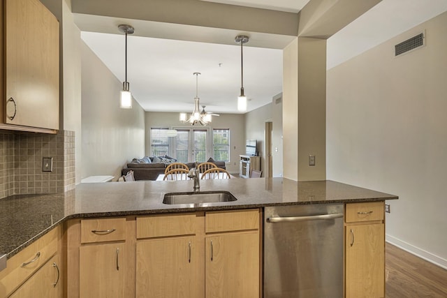 kitchen featuring pendant lighting, light brown cabinetry, kitchen peninsula, and sink