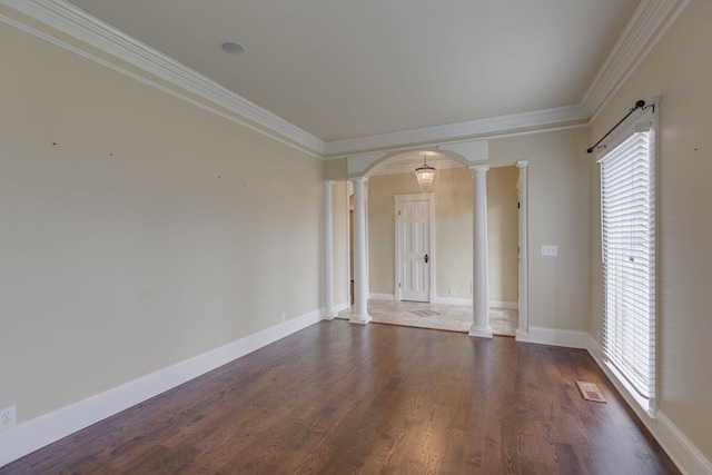 empty room with ornate columns, crown molding, and dark wood-type flooring