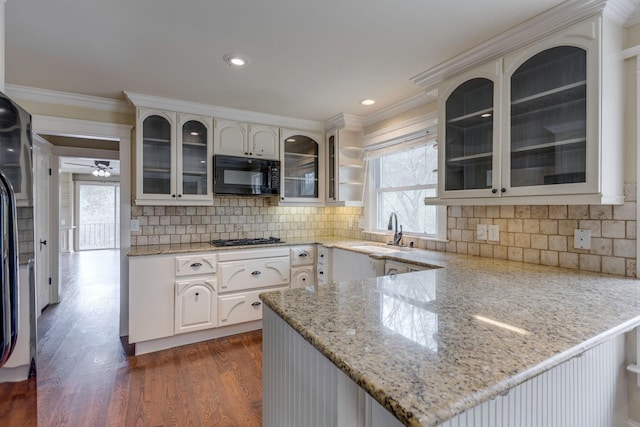 kitchen featuring sink, crown molding, light stone counters, black appliances, and kitchen peninsula