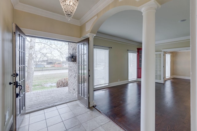 tiled foyer entrance featuring decorative columns, ornamental molding, and french doors