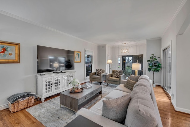 living room featuring ornamental molding, a chandelier, and light wood-type flooring