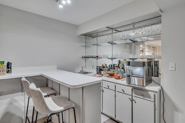 bar featuring white cabinetry and sink