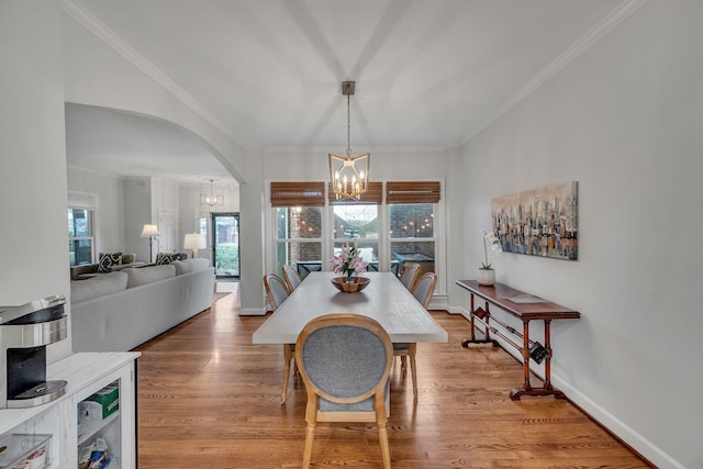 dining space featuring hardwood / wood-style flooring, crown molding, and a notable chandelier