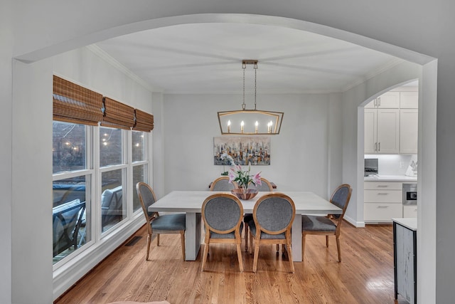 dining room featuring crown molding and light hardwood / wood-style floors