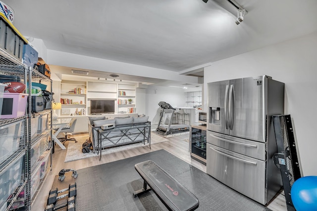 kitchen featuring stainless steel fridge with ice dispenser, light hardwood / wood-style flooring, and track lighting