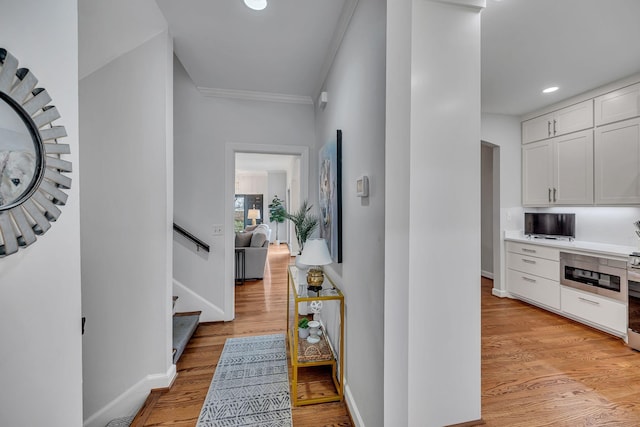 hallway featuring crown molding and light wood-type flooring