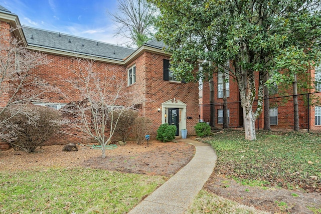 colonial-style house featuring a front yard