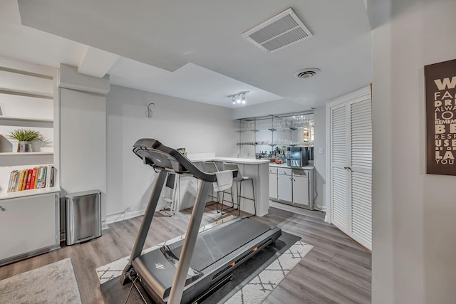 workout room featuring bar and light hardwood / wood-style floors