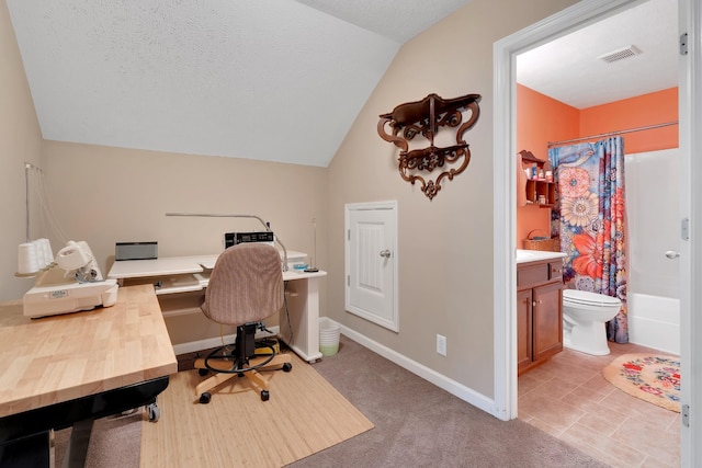 office space with vaulted ceiling, light colored carpet, and a textured ceiling