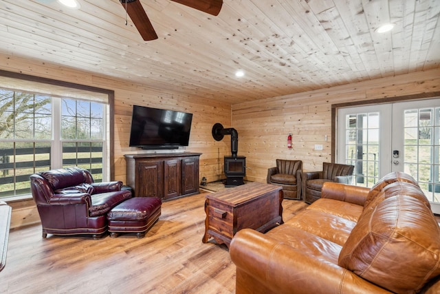 2111 Hoovers Rd, Duck River, TN 38454 - living room featuring french doors, wood walls, wood ceiling, light hardwood / wood-style flooring, and a wood stove