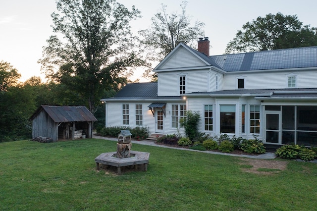 2111 Hoovers Rd, Duck River, TN 38454 - back house at dusk featuring an outbuilding and a yard