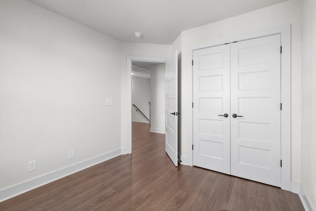 unfurnished bedroom featuring dark hardwood / wood-style flooring and a closet