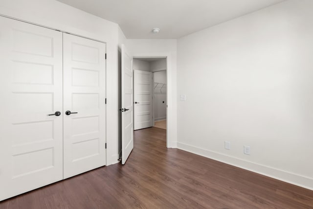 unfurnished bedroom featuring dark wood-type flooring and a closet