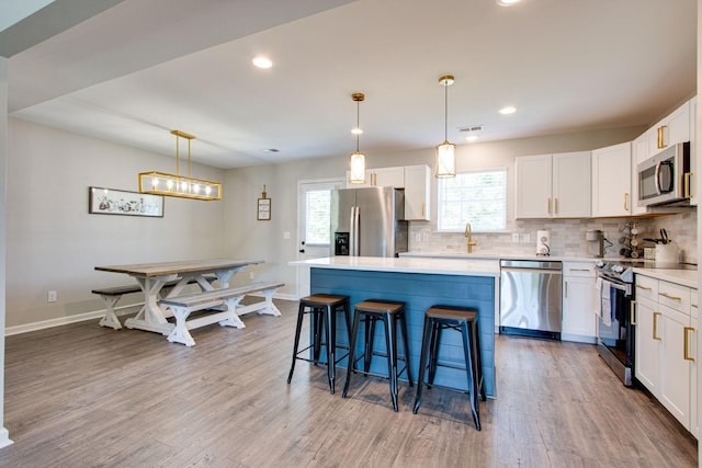 kitchen with pendant lighting, appliances with stainless steel finishes, and a kitchen island