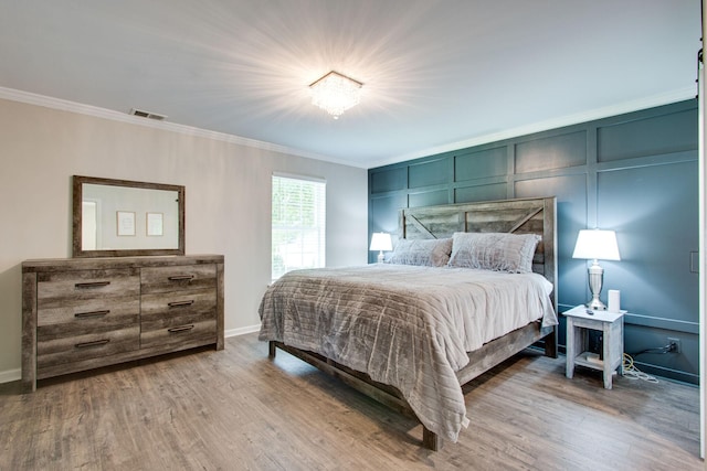 bedroom with crown molding and hardwood / wood-style floors