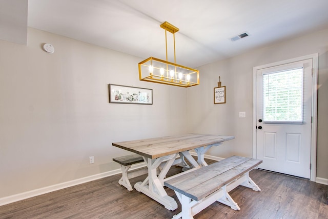 dining space with dark hardwood / wood-style floors and a chandelier