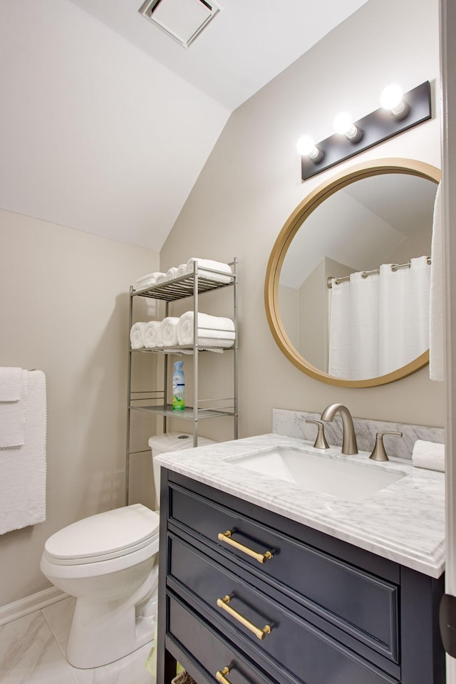 bathroom with lofted ceiling, toilet, and vanity