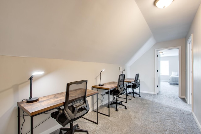 home office with lofted ceiling and light carpet