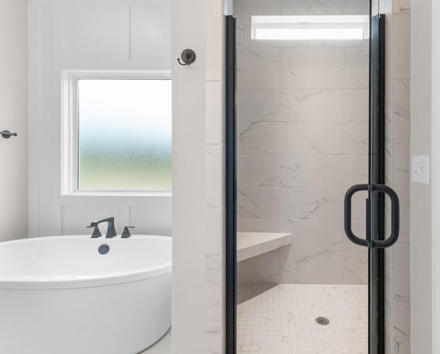 bathroom featuring shower with separate bathtub and a healthy amount of sunlight