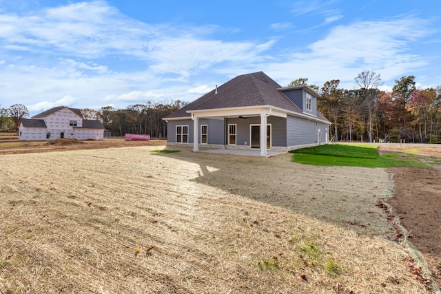 back of property with a yard, ceiling fan, and a patio area