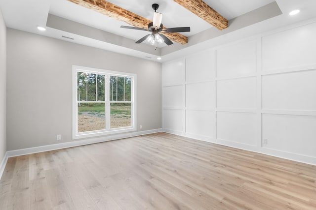 empty room featuring ceiling fan, beam ceiling, and light hardwood / wood-style floors