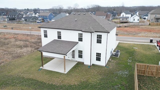 rear view of property featuring central AC unit, a yard, and a patio